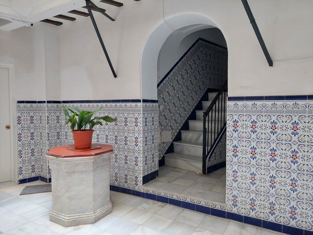 Kaakeloitua seinää ja portaikkoon johtava oviaukko