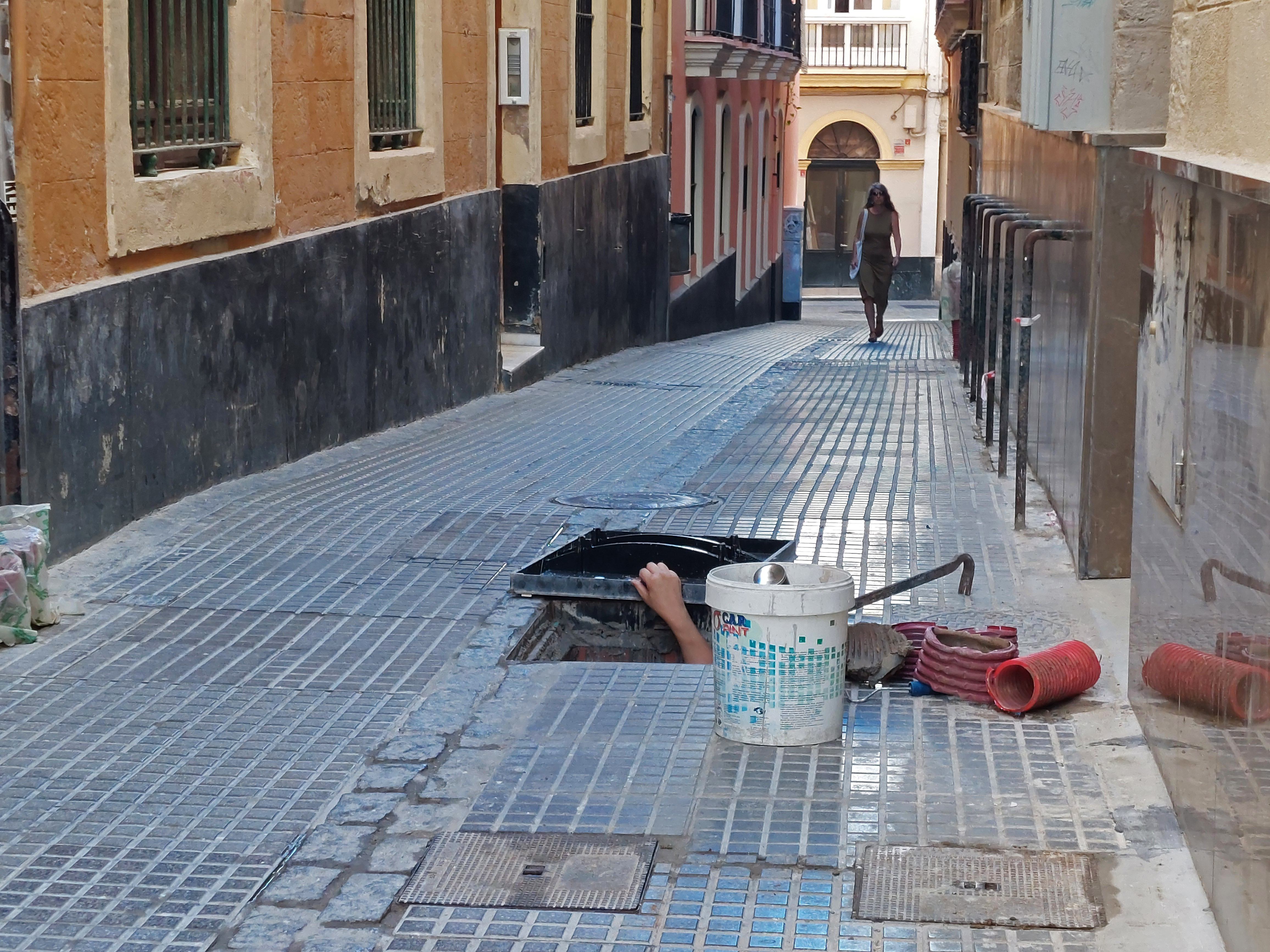 Katukaivosta kurkottaa käsi ja vieressä työkaluja