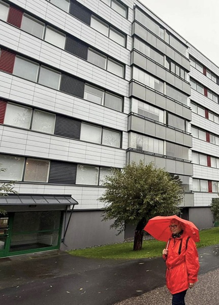 Kerrostalo ja puna-asuinen henkilö