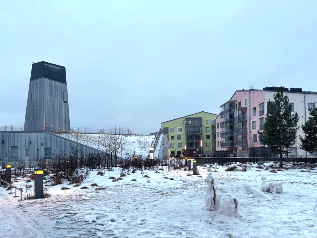 Harppuunakorttelin piha-aluetta. Etualalla lumihevonen ja muita lumihahmoja.